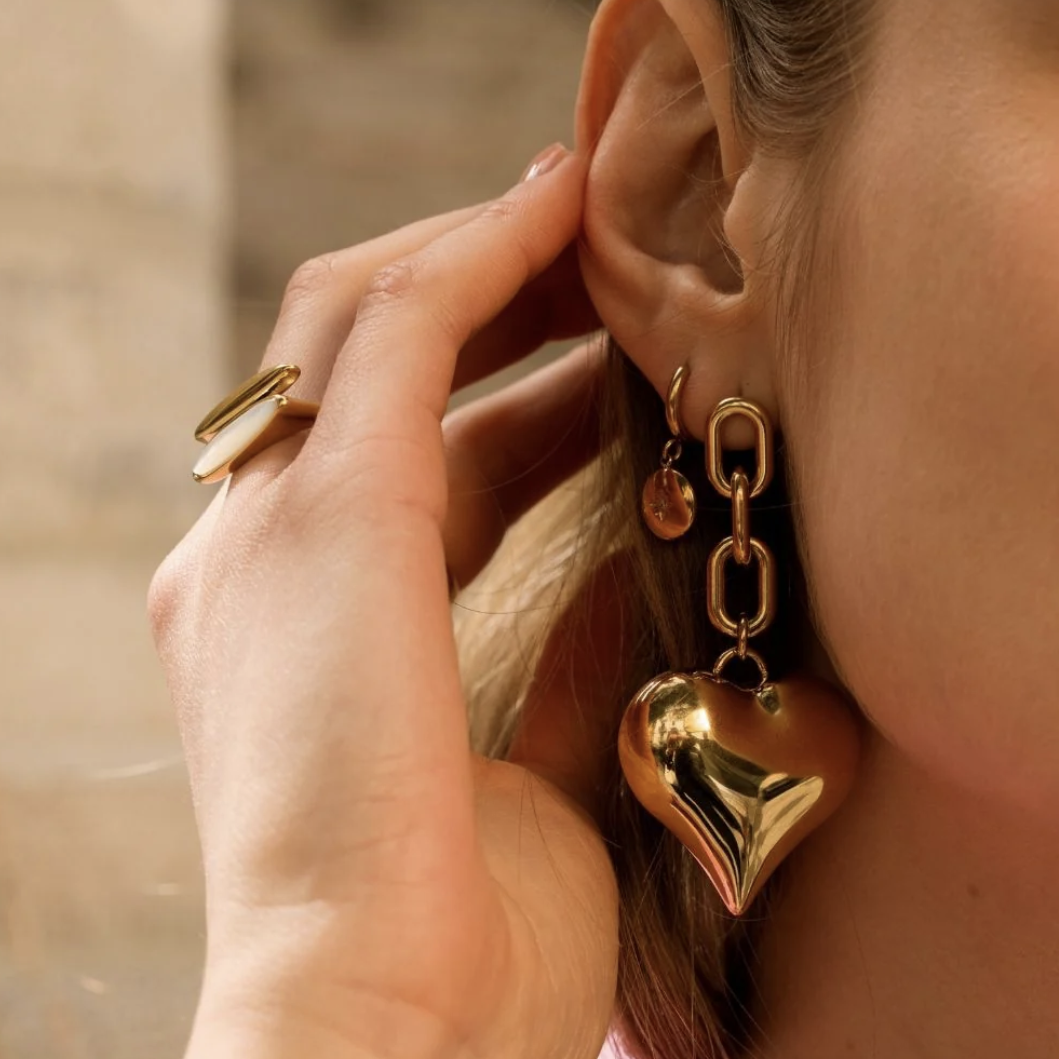 Mathilde & Filles | Boucles d'oreilles en acier inoxydable embellies d'un gros cœur en 3D accroché à une chaine composée de maillons