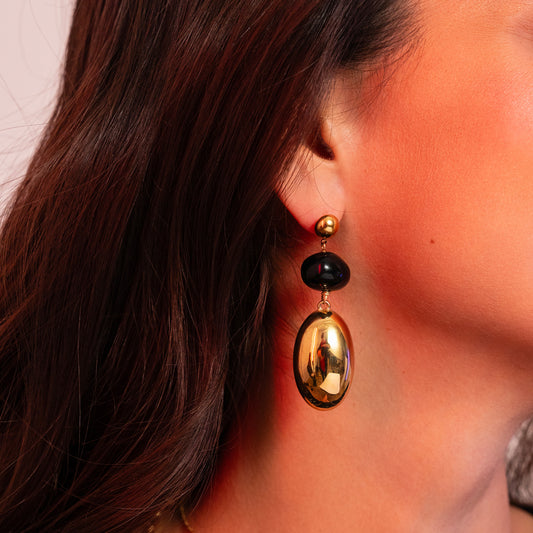 Mathilde & Filles | Boucles d'oreilles composées d'une pièce en forme de boule en acétate noire et d'une pièce en forme d'olive dorée